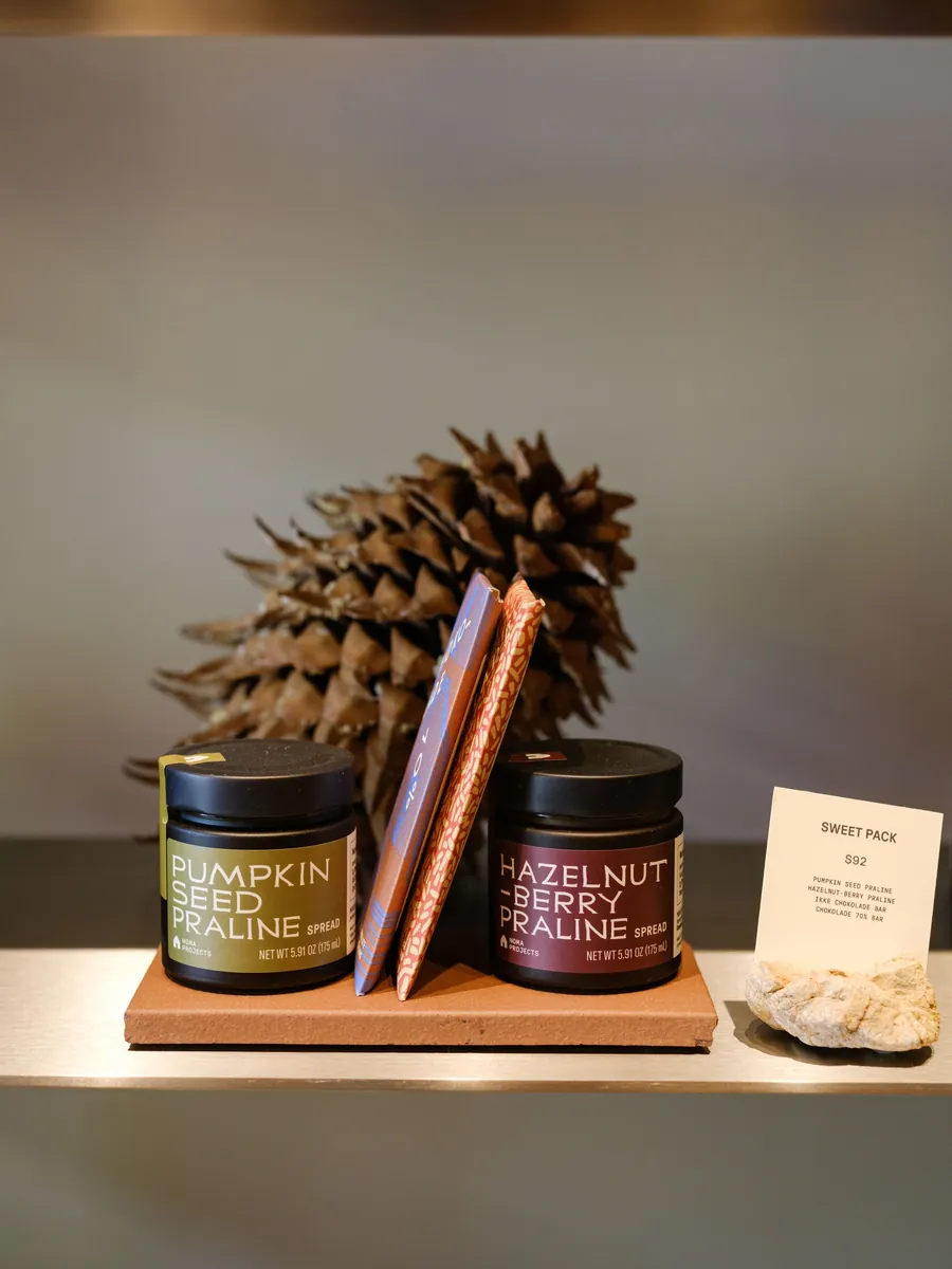 Jars of Noma Projects Pumpkin Seed Praline and Hazelnut Berry Praline on a shelf